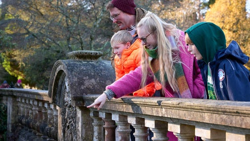 A family standing on a bridge at Sheffield Park and Garden